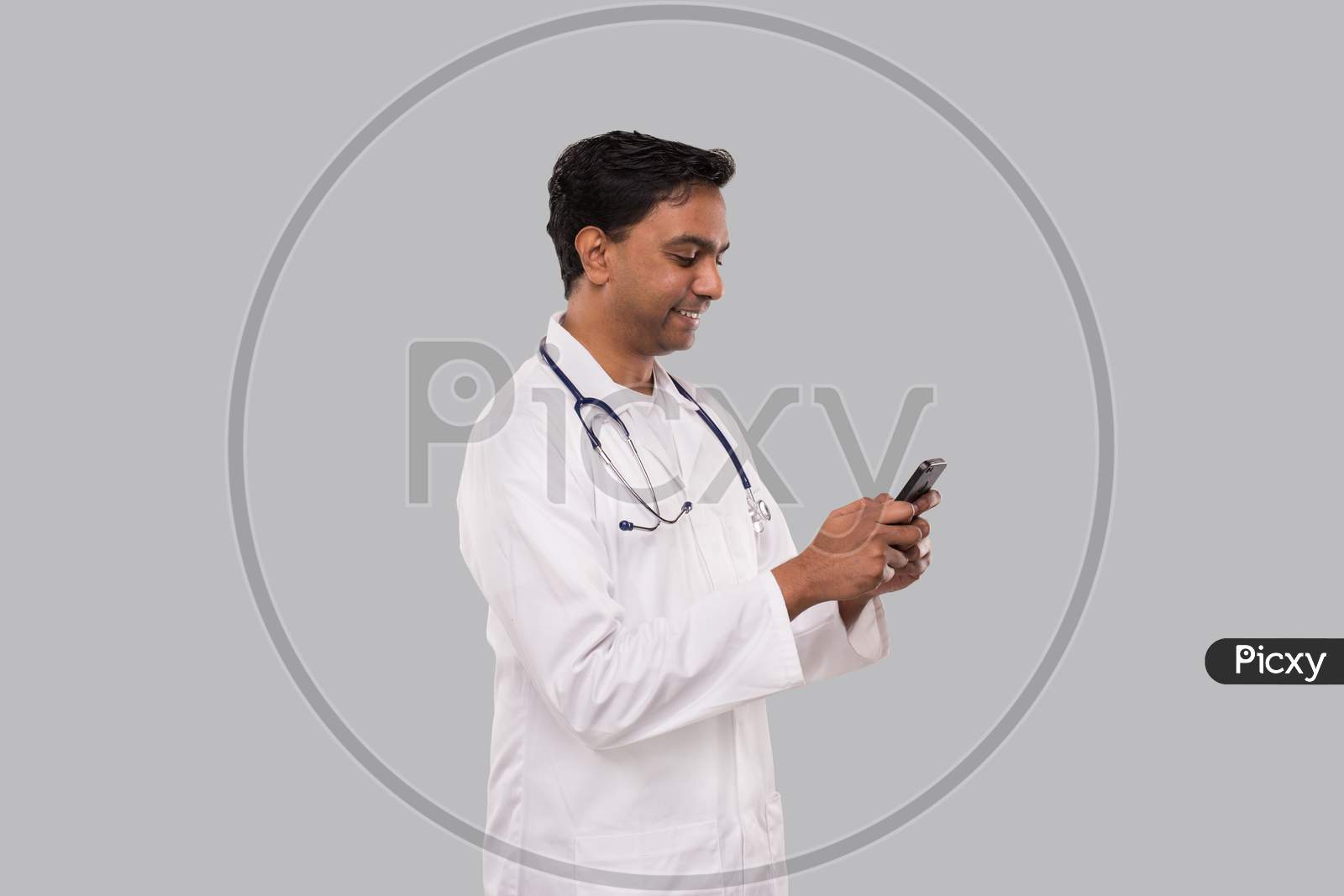Doctor Chatting On The Phone Isolated. Indian Man Doctor With Phone. Online Medicine