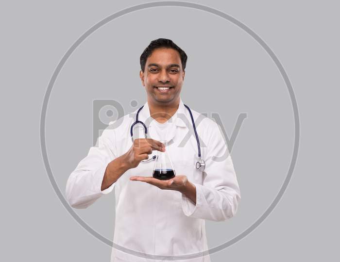 Male Doctor Showing Flask With Colorfull Liquid Isolated. Science, Medical, Virus Concept. Indian Man Doctor Smilling.