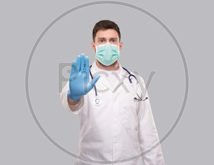 Male Doctor Showing Stop Sign. Doctor Wearing Medical Mask And Gloves. Focus On Hand. Stop Virus Concept