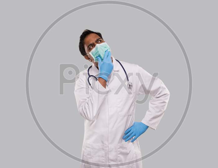 Indian Man Doctor Thinking Sign Wearing Medical Mask And Gloves. Doctor Watching Up. Isolated