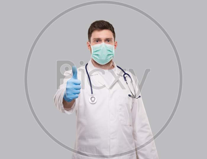 Male Doctor Showing Thumb Up Wearing Medical Mask And Gloves.