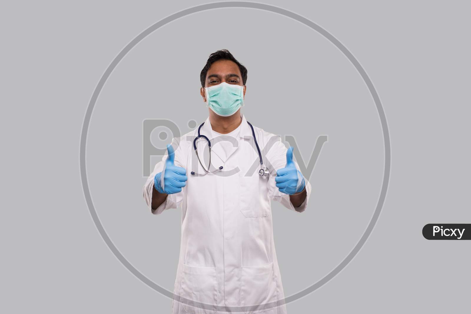 Doctor Showing Thumb Up Both Hands Smilling Wearing Medical Mask And Gloves. Indian Man Doctor Isolated