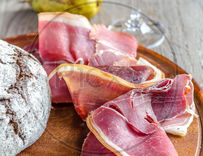 Slices of italian ham on the wooden board