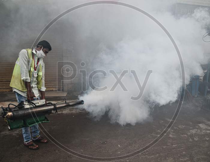 A corporation worker fumigates chemical smoke to prevent the spread of mosquito-borne diseases during the monsoon season in Vijayawada.