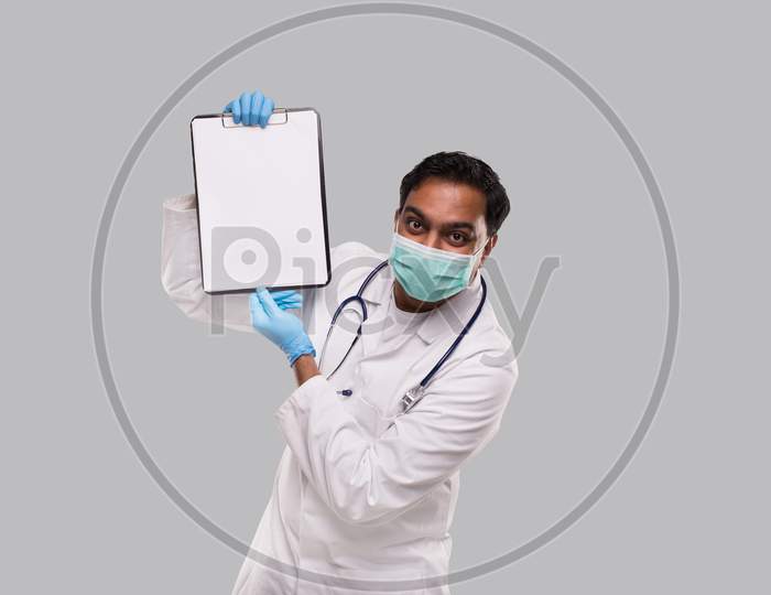 Doctor Showing Clipboard Wearing Medical Mask And Gloves Isolated. Indian Man Doctor Blank Clipboard In Hands