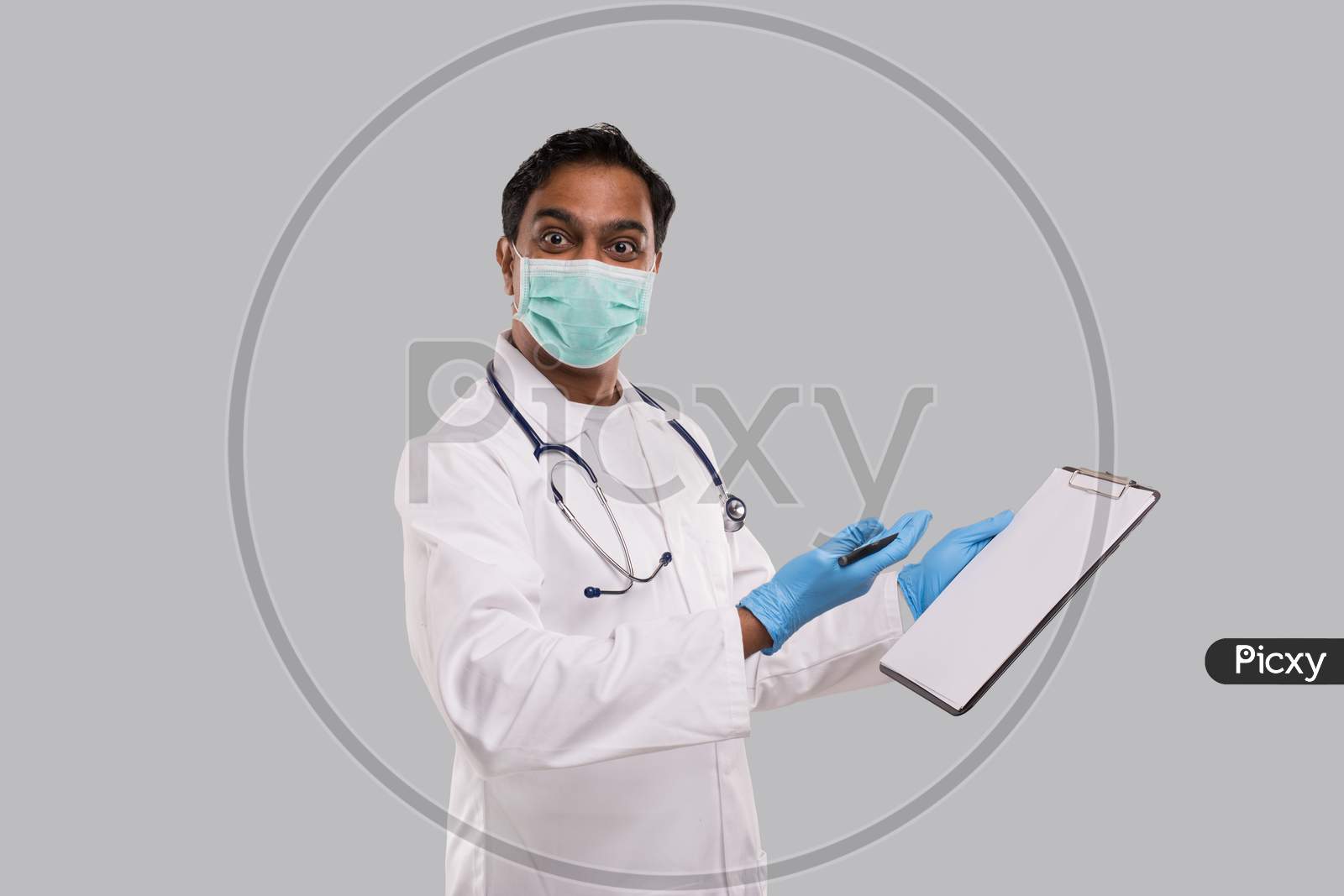 Doctor Writing In Clipboard Watching In Camera. Indian Man Doctor Clipboard Isolated