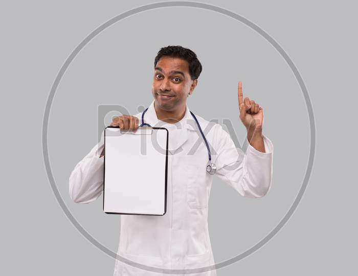 Doctor Pointing Up Clipboard Isolated. Indian Man Doctor Blank Clipboard In Hands. Male Doctor With Great Idea