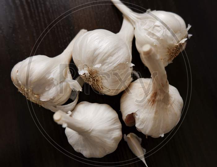 Top Shot Of Garlic'S & Cloves On Wooden Background