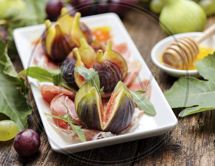 Parma ham with figs on a wooden table