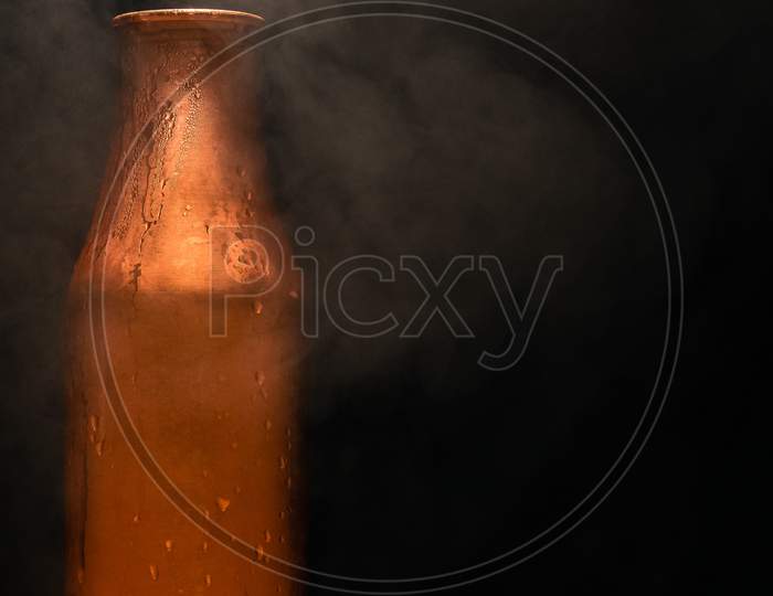 jug of milk on black background with smoke