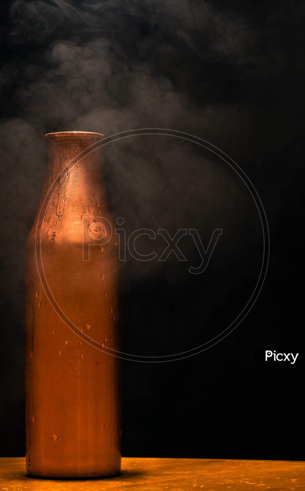 jug of milk on black background with smoke