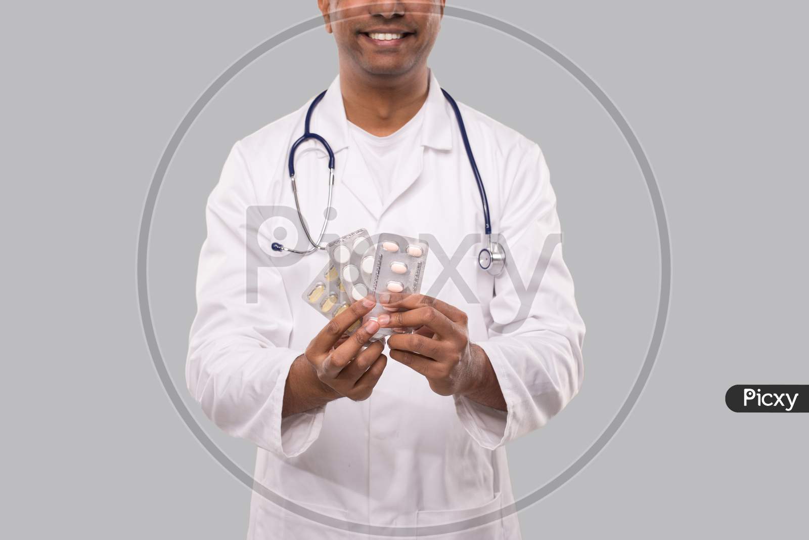 Man Doctor Showing Pills Close Up. Doctor Holding Tablets. Indian Man Doctor Isolated.