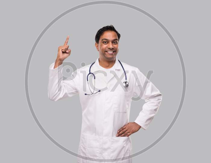 Indian Man Doctor Pointing Up And Watching To Camera. Isolated