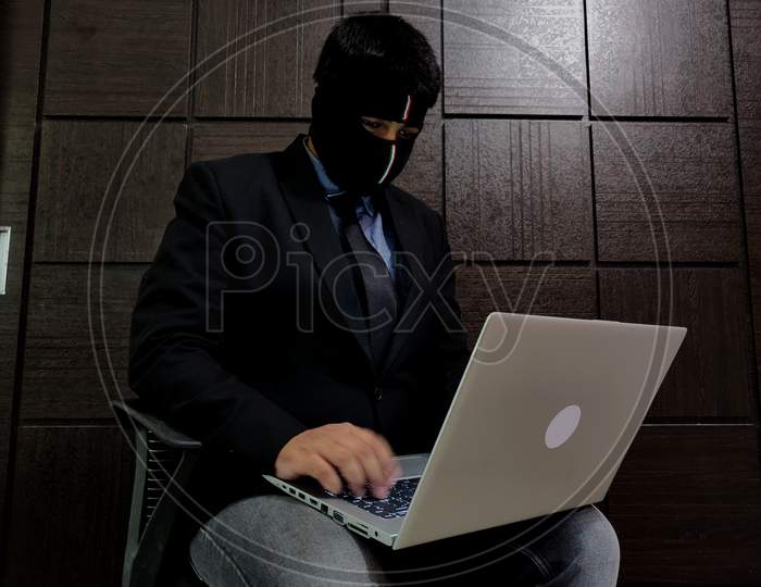 A Young Man Wearing Mask And Is Working On A Laptop