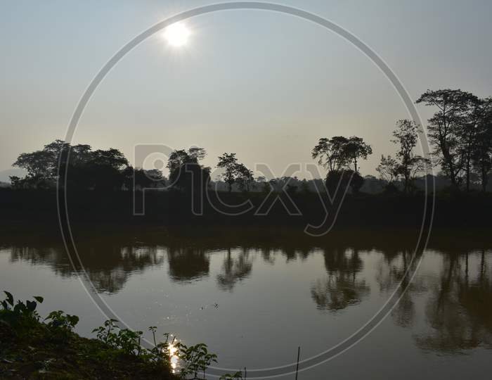 an evening sky beside a lake in a Village of Assam