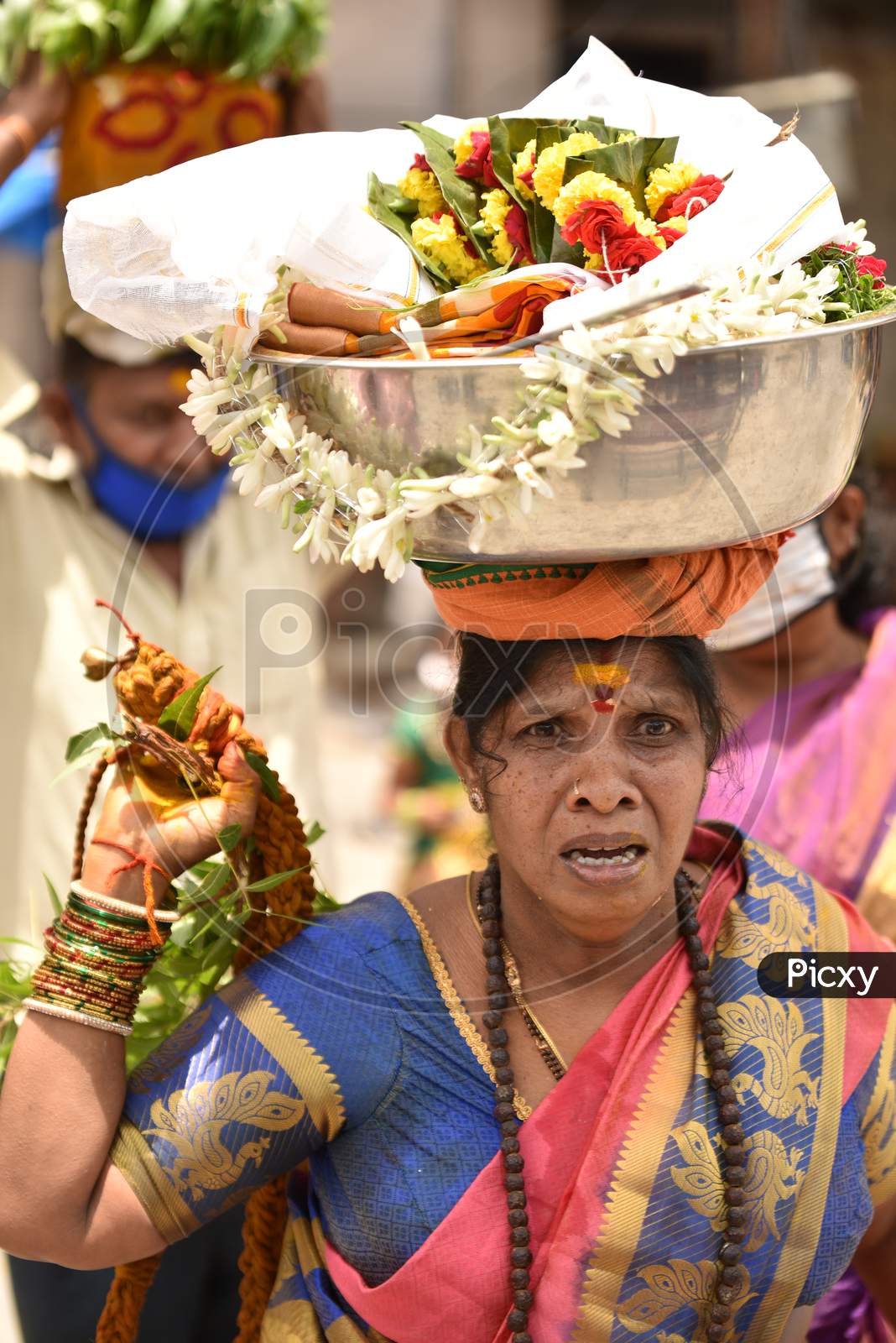 A woman reacts with a 'Bonam' offering on her head outside a closed Yellamma Pochamma temple in Balkampet, Bonalu 2020, Hyderabad, July 19.