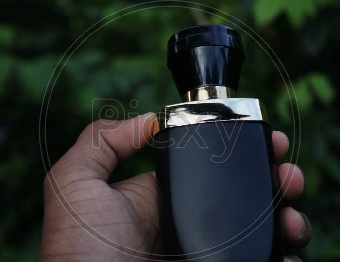 Perfume bottle catch the hand with natural background