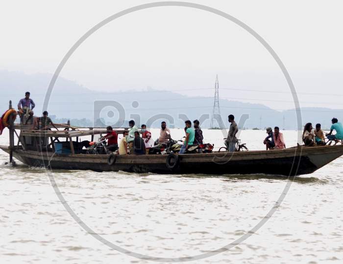 Villagers use a boat to navigate through the flood-affected areas in Morigaon, Assam on July 18, 2020