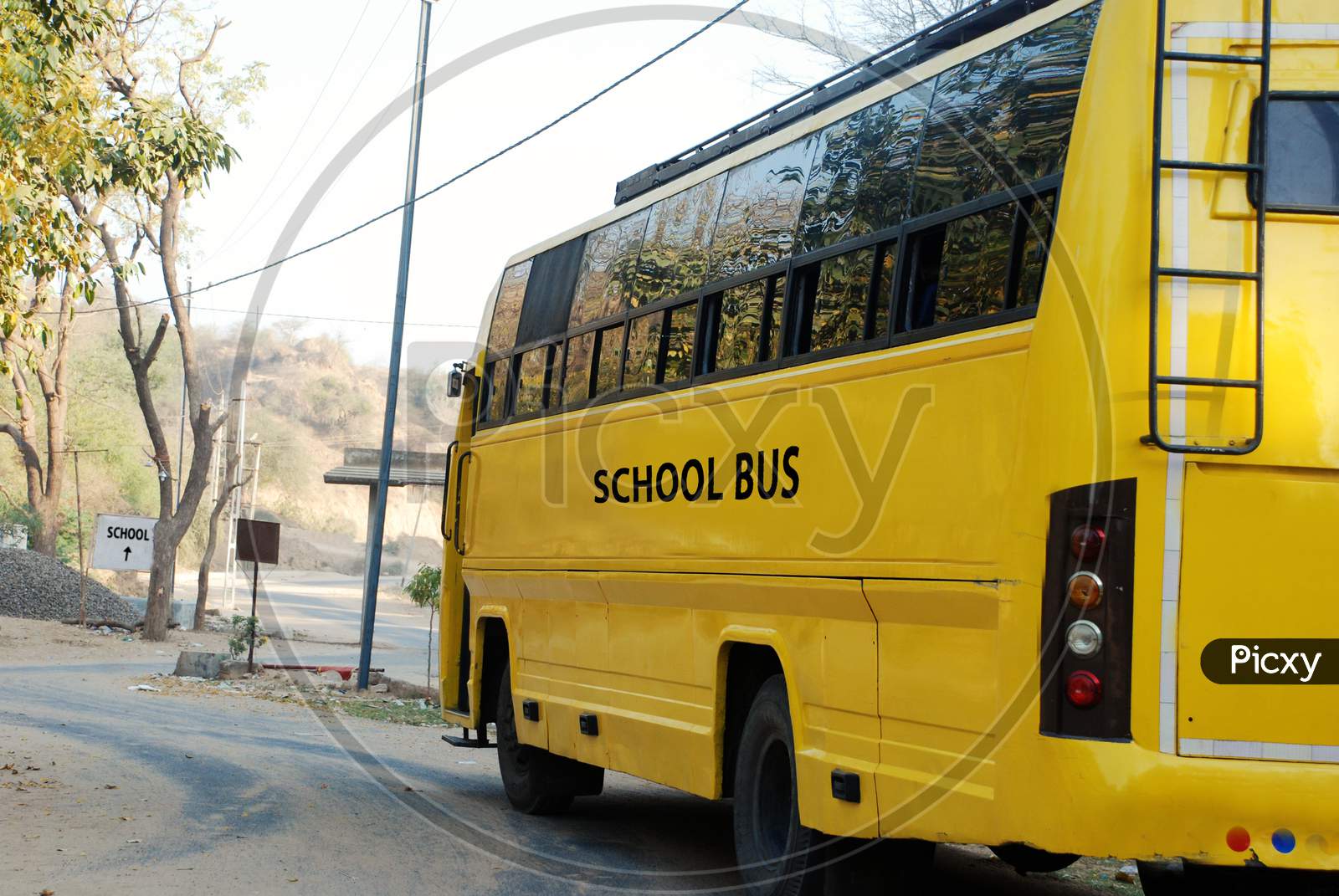 Yellow School Bus In Rural Village Road