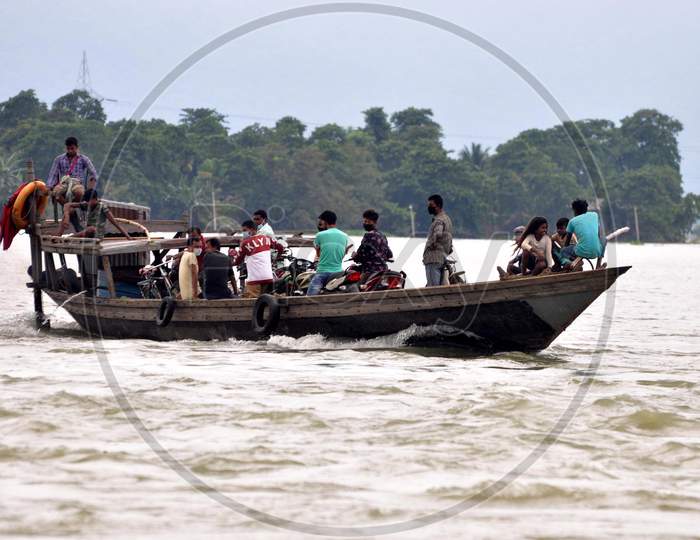 Villagers cross a flooded area on a boat at Mayong village in Morigaon, Assam on July 18, 2020
