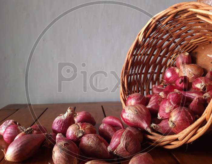 Shallots In Wicker Basket That Tilt And Spill Are Scattered