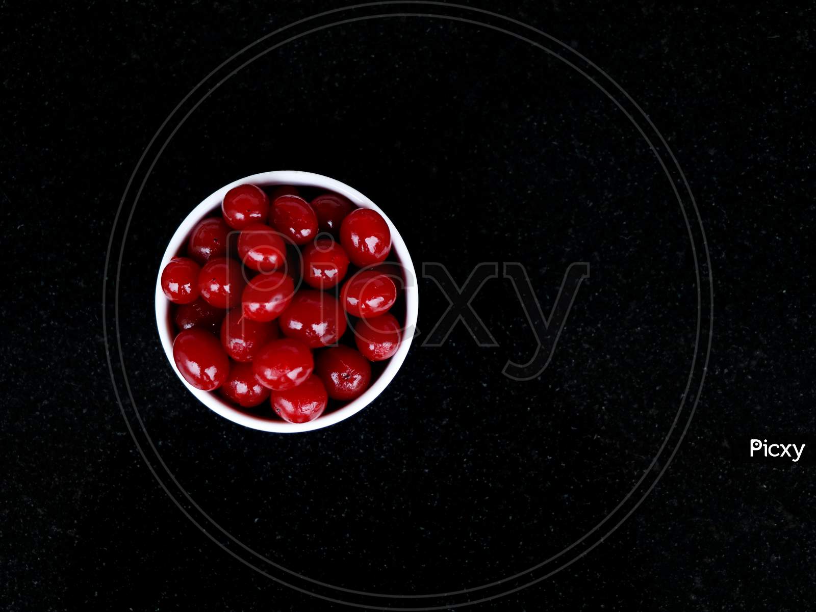 Red Color Cherry Fruits In A White Bowl Against Dark Background, With Copy Space, Caption