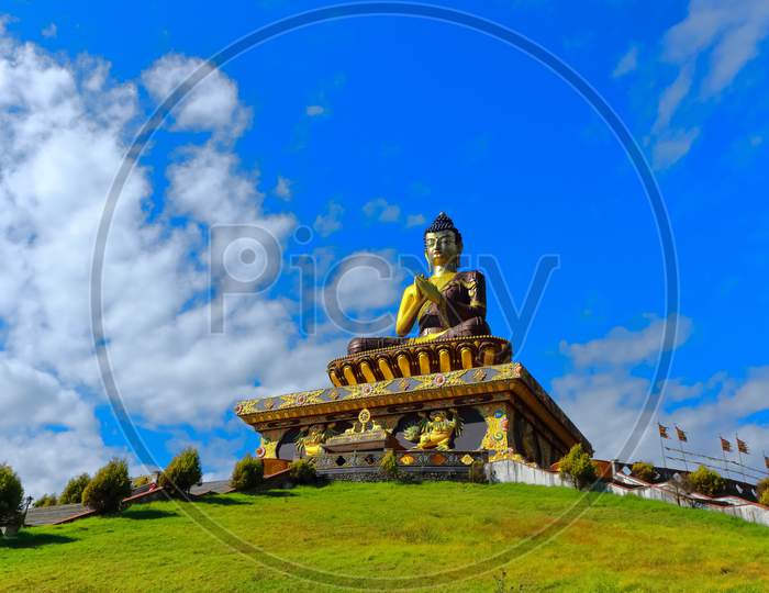 The statue of Buddha  with blue sky and clouds