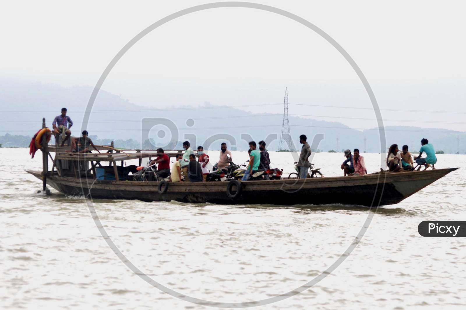 Villagers use a boat to navigate through the flood-affected areas in Morigaon, Assam on July 18, 2020