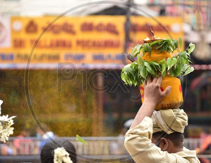 A man carries a 'Bonam' outside Yellamma Pochamma temple, July 19, 2020,Balkampet,Hyderabad.