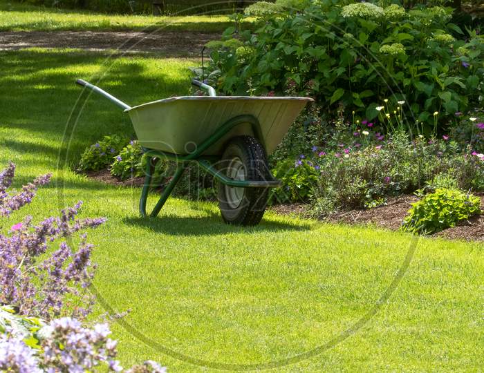 Wheelbarrow Full Of Weeds In Garden. No People. Concept Of Keeping Fit With Gardening And Helping Environment