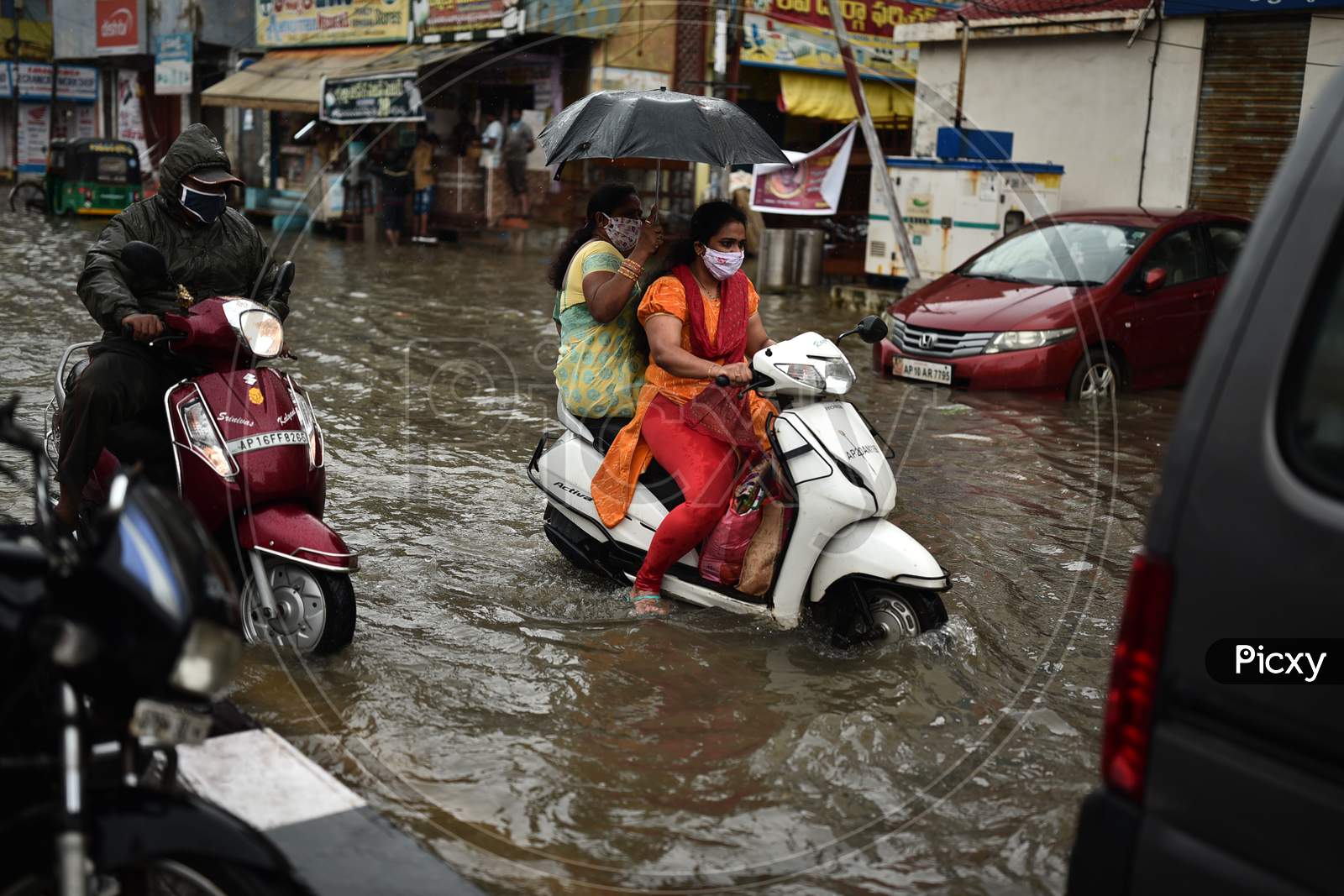 A Commuter Drives Through A Water-Logged Road During Heavy Rain In Vijayawada.