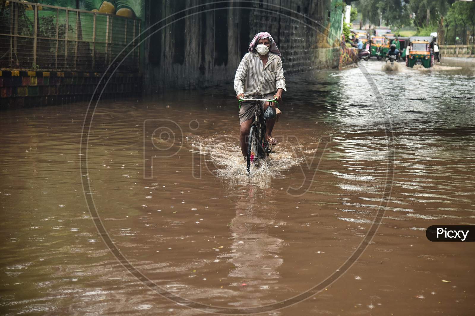 A Man Rides A Bicycle Through A Water-Logged Road During Heavy Rain In Vijayawada.