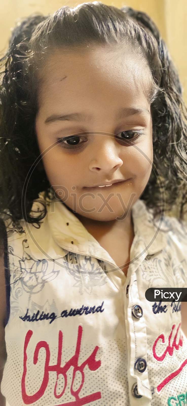 A cute curly hair Asian Indian baby playing in home