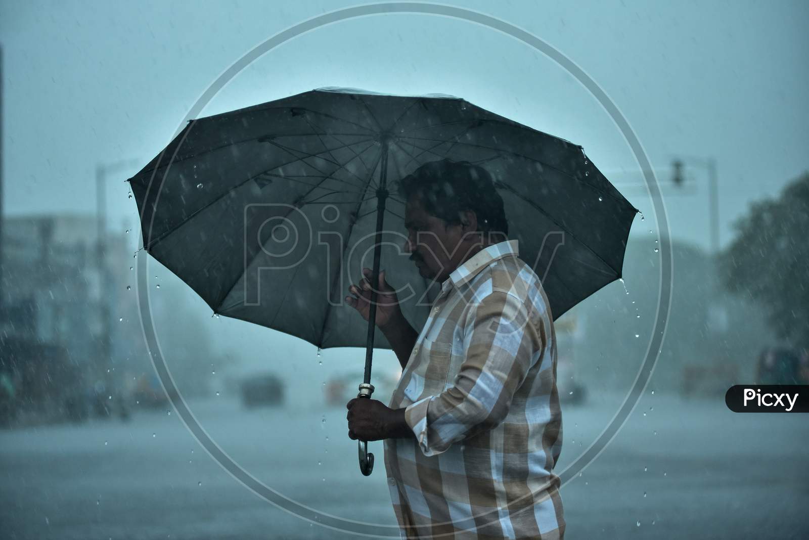 A Man Walks With An Umbrella During Heavy Rain In Vijayawada.