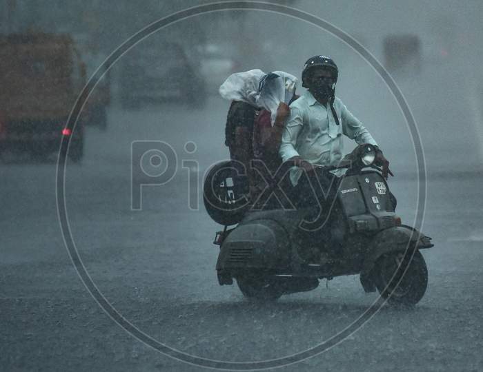 A Commuter Rides During Heavy Rain In Vijayawada.