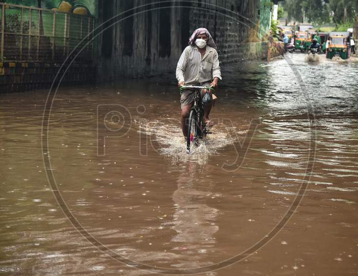 A Man Rides A Bicycle Through A Water-Logged Road During Heavy Rain In Vijayawada.