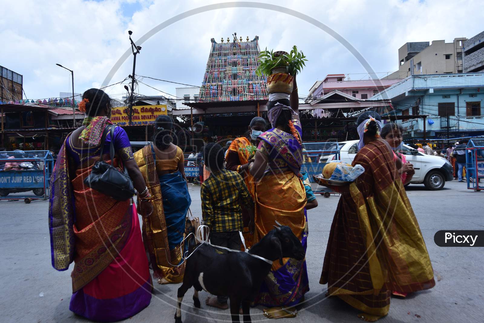 Devotees wait in front of a closed Yellamma Pochamma Temple to offer their 'Bonam' amid raising fears of coronavirus, July 19, 2020, Balkampet, Hyderabad, Bonalu 2020.