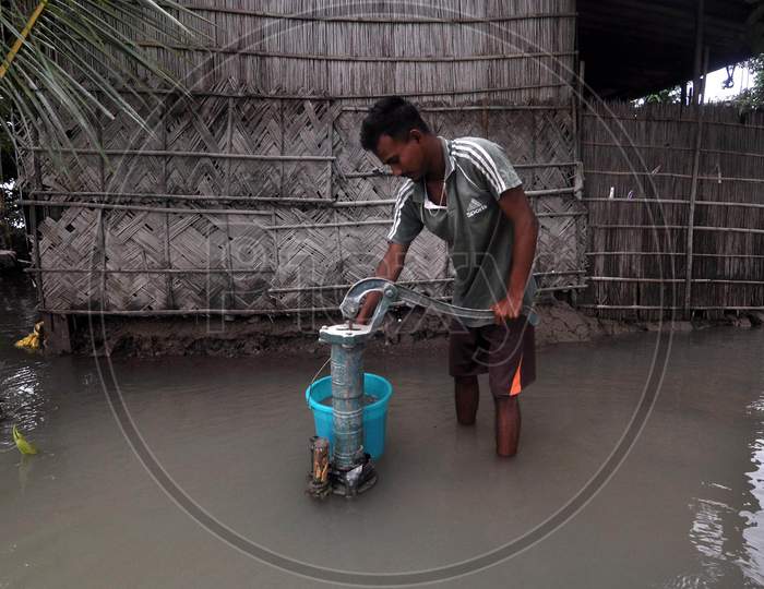 A boy uses a hand pump to collect drinking water in a flood-affected locality in Morigaon, Assam on July 18, 2020
