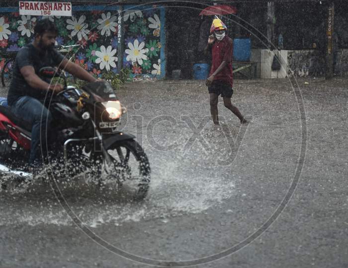 A Man Wades Through A Water-Logged Road During Heavy Rain In Vijayawada.