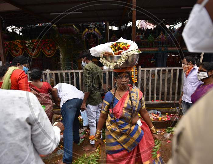A woman dances with a 'Bonam' offering on her head outside a closed Yellamma Pochamma temple in Balkampet, Bonalu 2020, Hyderabad, July 19.