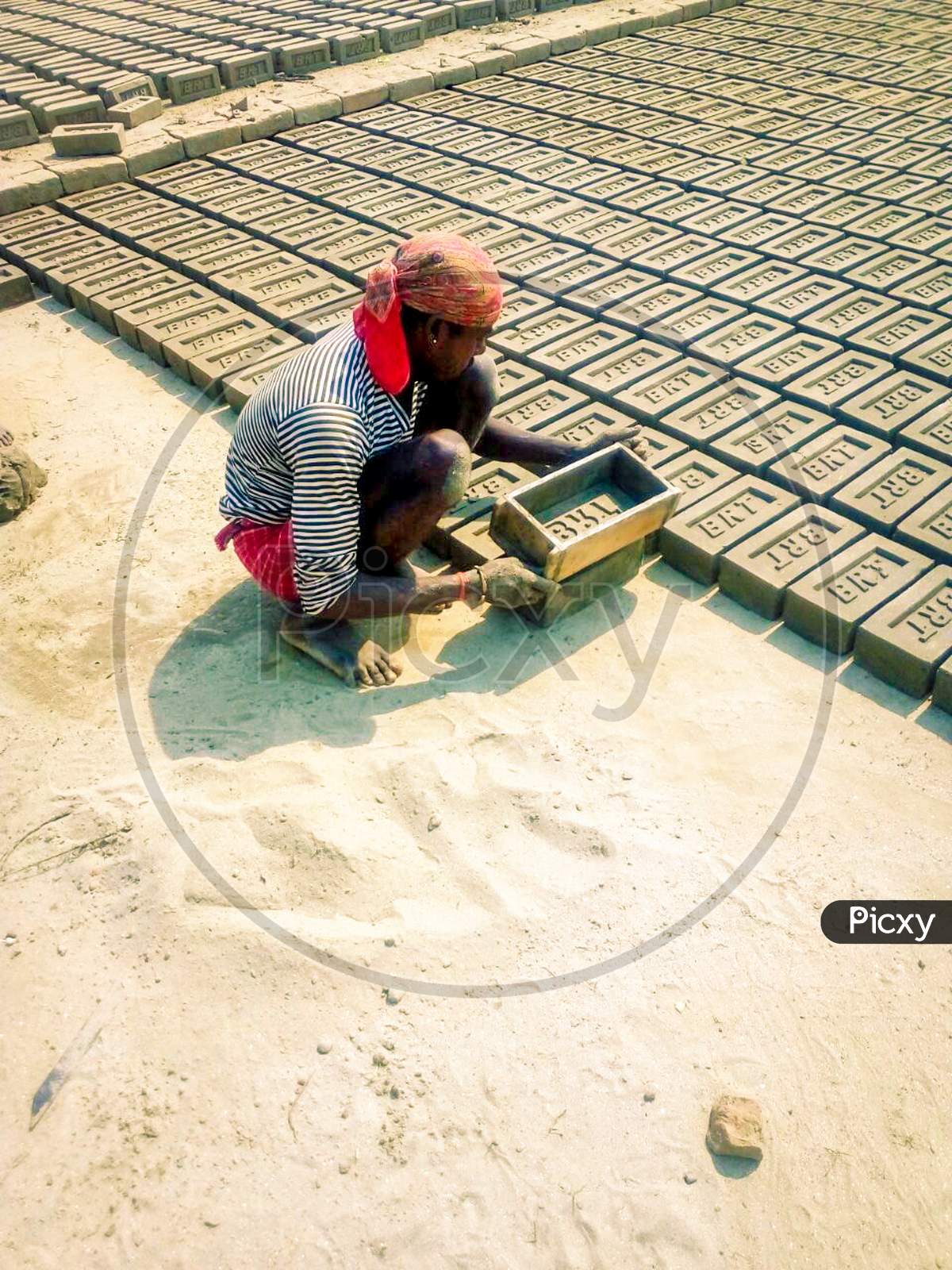 A worker is making bricks. How many people like him have been making hundreds of bricks by labour. How many big buildings are being built with these bricks.