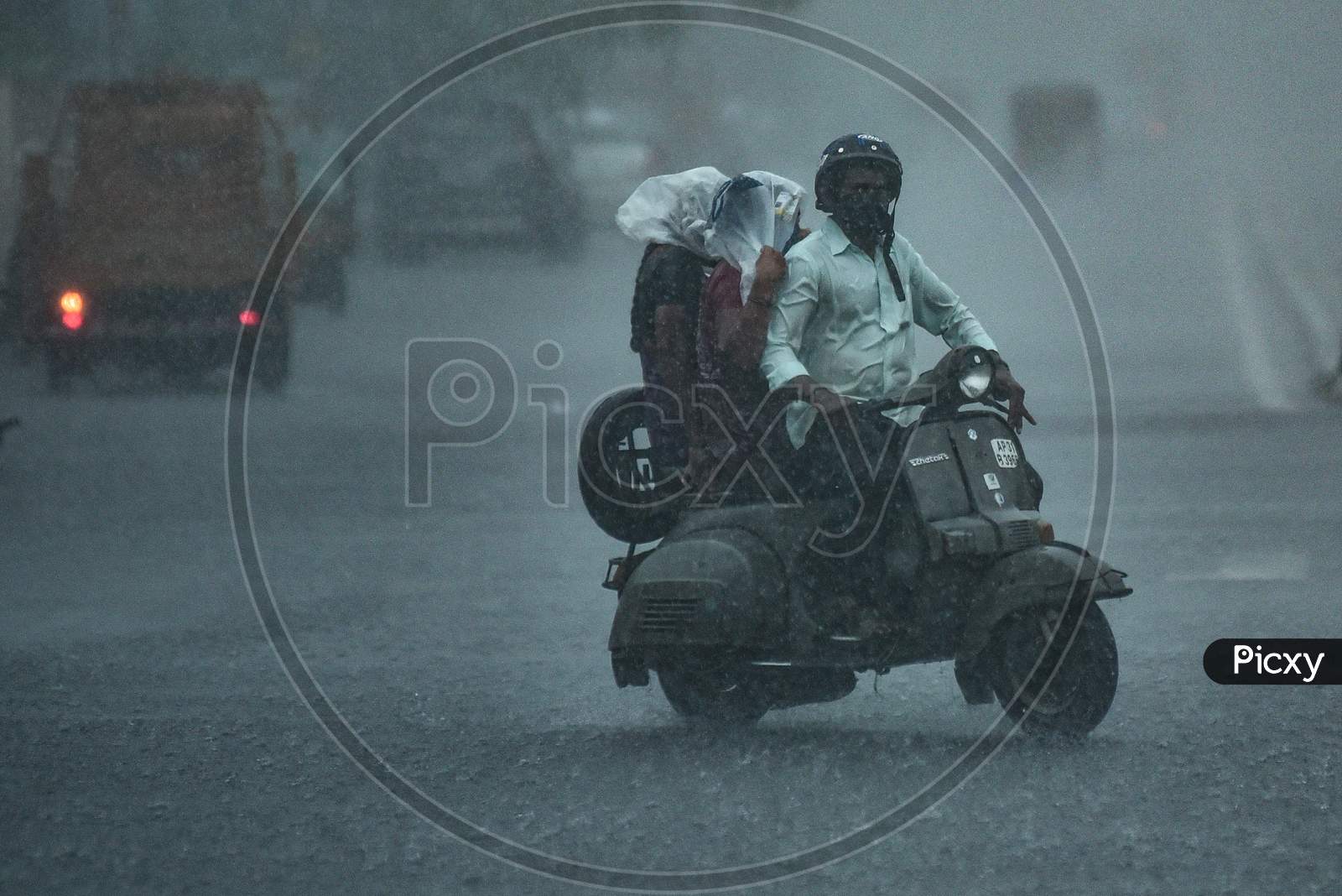 A Commuter Rides During Heavy Rain In Vijayawada.