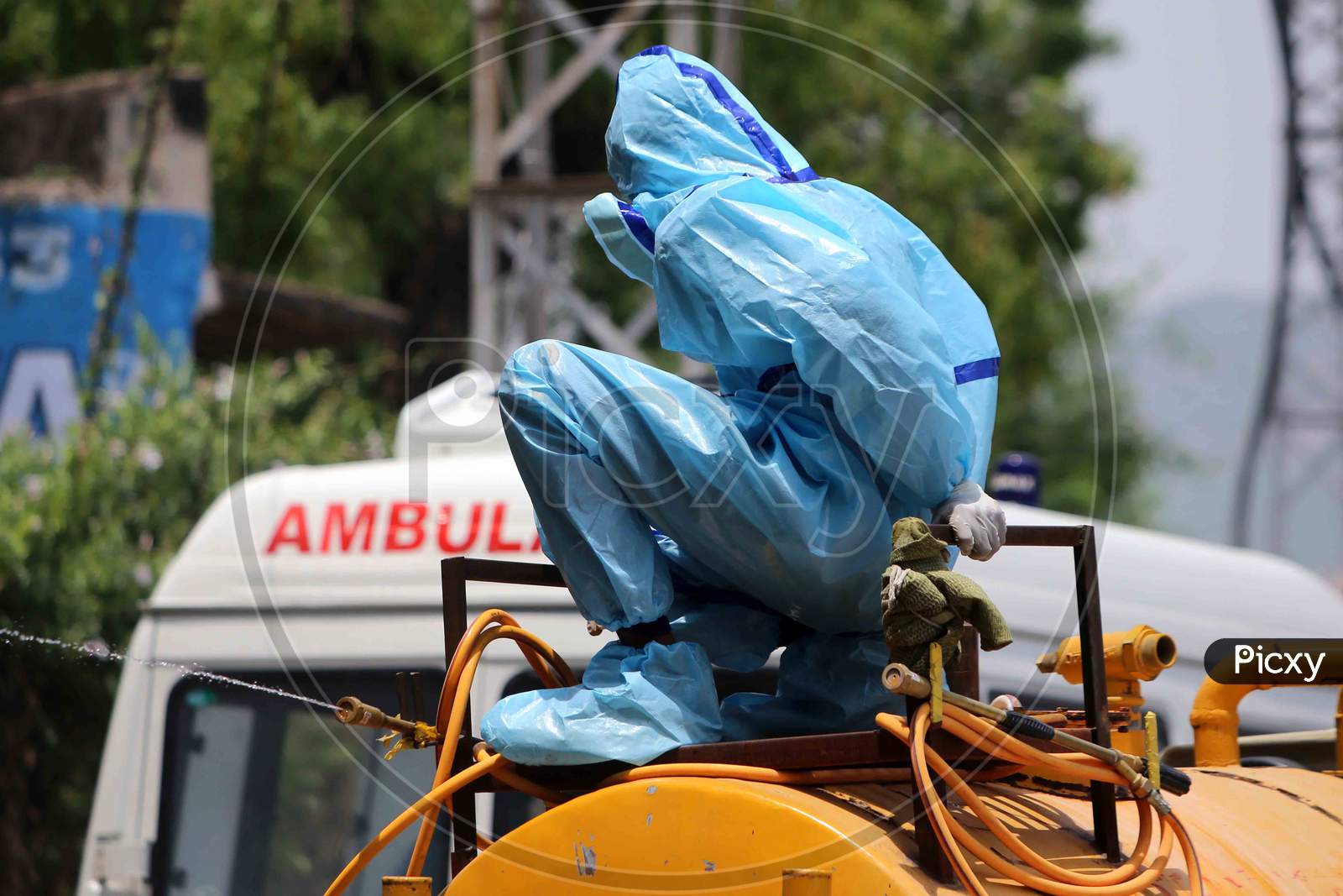 A municipal worker wearing a hazmat suit sits on a truck filled with a disinfectant in Ajmer, Rajasthan on July 02, 2020.