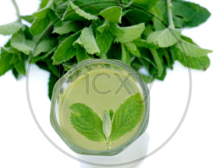 the lamon juice in the glass with green mint and leaves