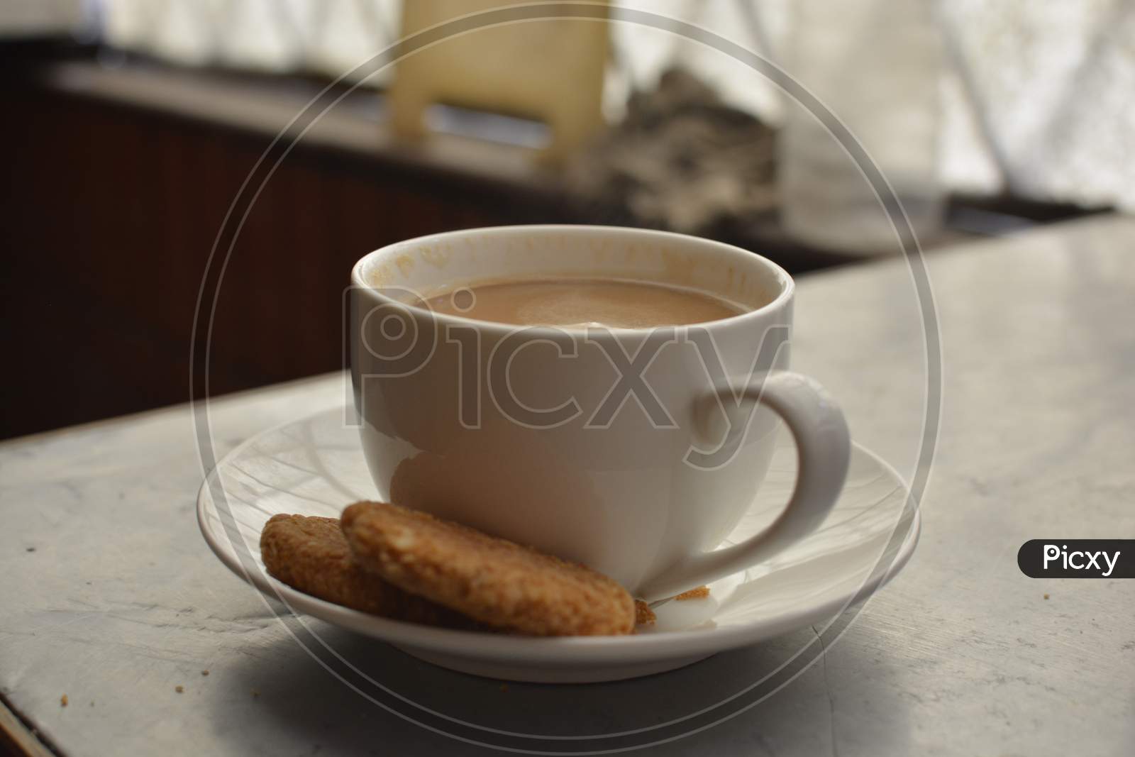 Hot milk tea in white Cup with cookies