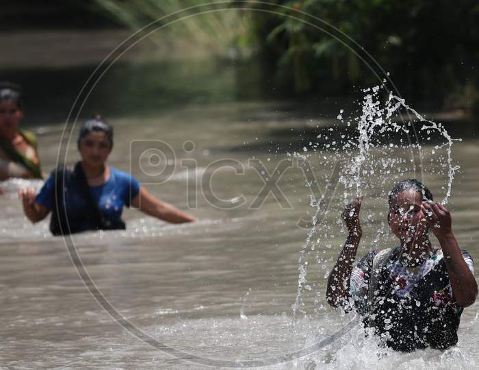 Woman splashing cool water on her face from Ranbir Canal as temperature rises in Jammu on July 2, 2020.