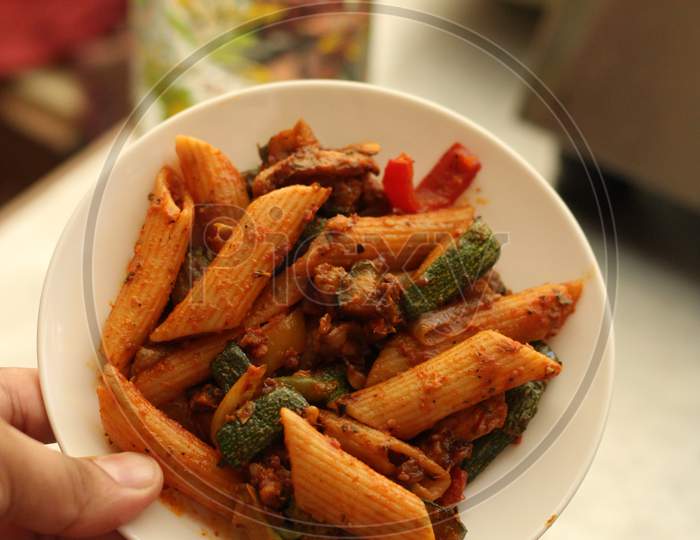 Spicy pasta on small white plate