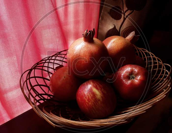 Fruits in a basket citrus pomegranate apple vibrant in colour