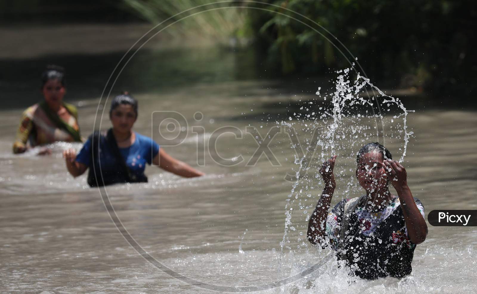Woman splashing cool water on her face from Ranbir Canal as temperature rises in Jammu on July 2, 2020.