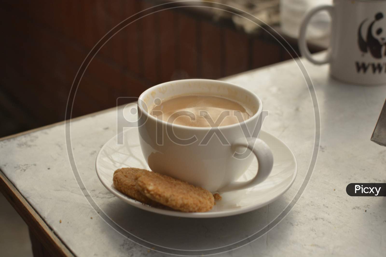 Hot milk tea in white Cup with cookies